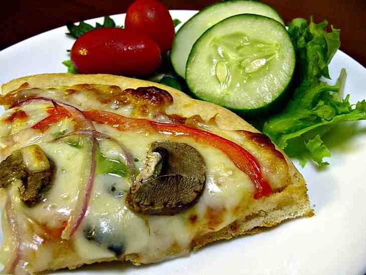 Mushrooms, Peppers And Red Onion Melt Into A Slice Of Cheesy Pizza Accompanied By Fresh Cucumbers And Tomatoes